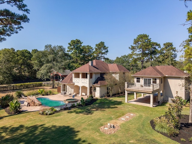 rear view of house featuring a balcony, a yard, and a patio area