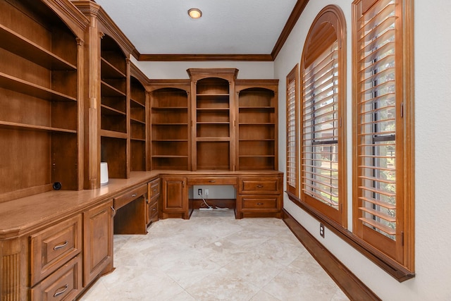 office area with crown molding and built in desk