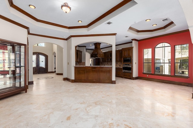 kitchen featuring crown molding, a tray ceiling, and plenty of natural light