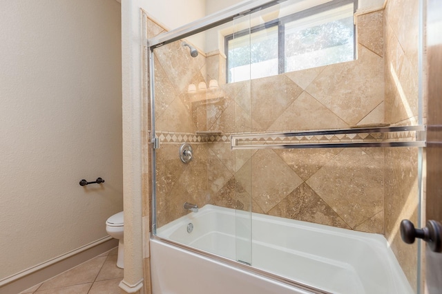 bathroom featuring shower / bath combination with glass door, tile patterned floors, and toilet