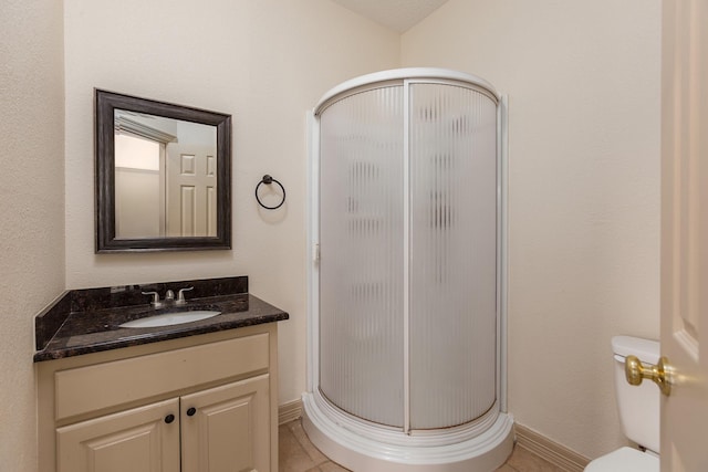 bathroom featuring vanity, an enclosed shower, tile patterned flooring, and toilet