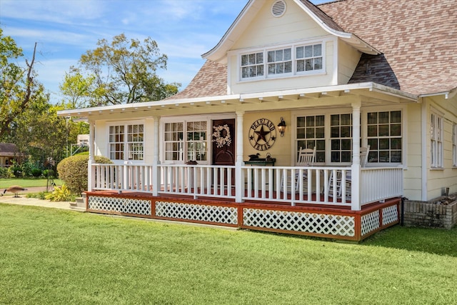 rear view of property with a yard and covered porch