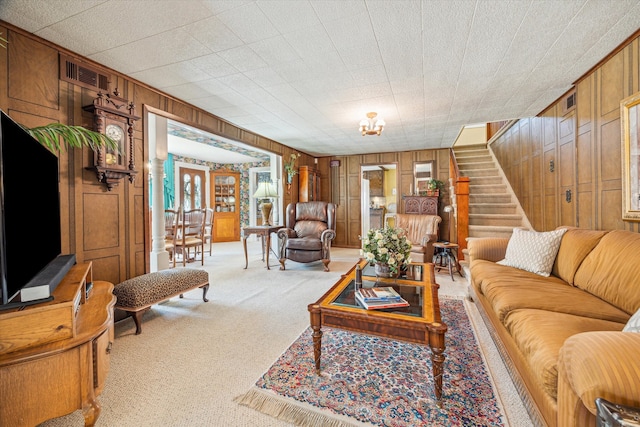 living room featuring wood walls and light carpet