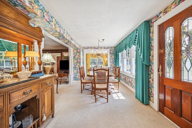 carpeted dining room with a chandelier