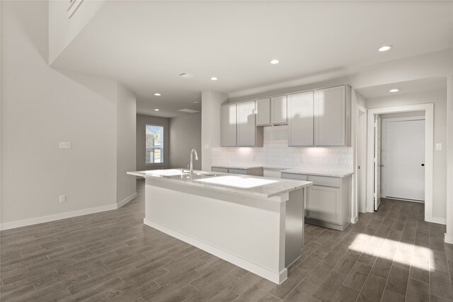 kitchen featuring a center island with sink, dark hardwood / wood-style floors, gray cabinetry, and sink