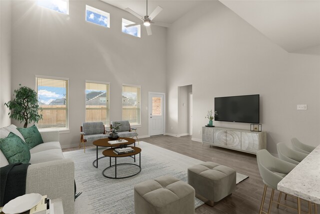 living room featuring hardwood / wood-style floors, ceiling fan, and high vaulted ceiling