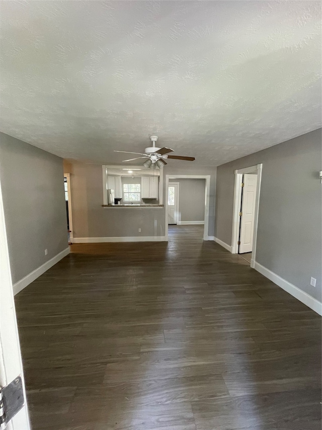 unfurnished living room featuring a textured ceiling, ceiling fan, and dark hardwood / wood-style flooring