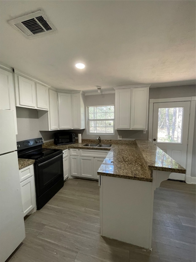 kitchen featuring black appliances, sink, dark stone counters, white cabinets, and light hardwood / wood-style flooring