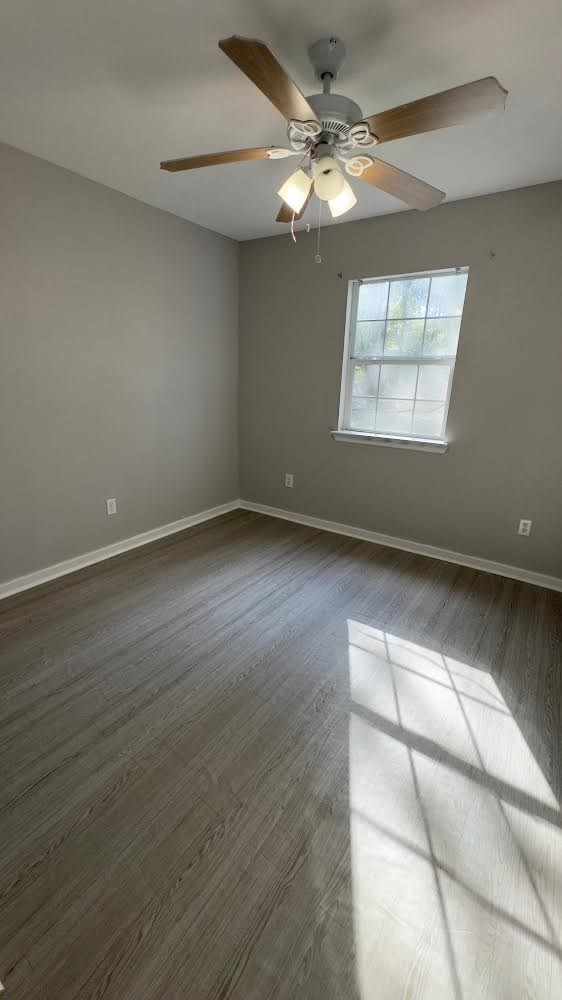 spare room featuring ceiling fan and dark hardwood / wood-style floors