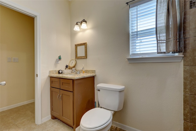 bathroom featuring tile patterned flooring, vanity, and toilet