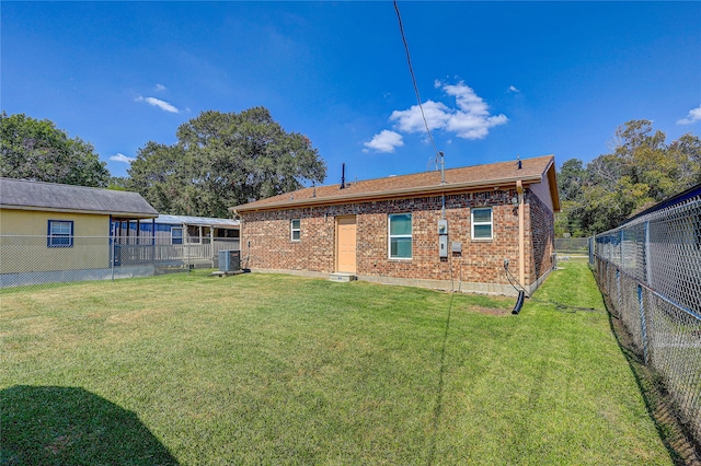 back of house featuring a yard and central air condition unit