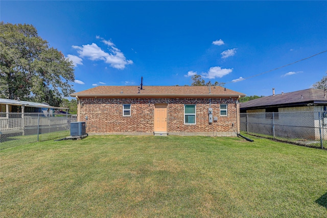 back of property with central AC and a yard