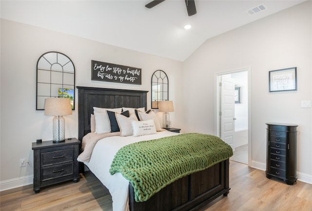 bedroom featuring ceiling fan, light hardwood / wood-style flooring, connected bathroom, and vaulted ceiling