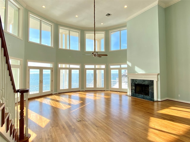 unfurnished living room with a water view, plenty of natural light, and french doors