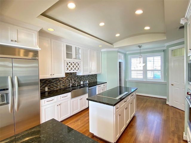 kitchen with hanging light fixtures, white cabinets, dark hardwood / wood-style flooring, stainless steel appliances, and sink