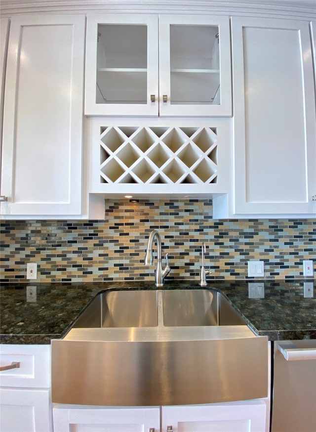 kitchen with dark stone counters, decorative backsplash, and white cabinetry