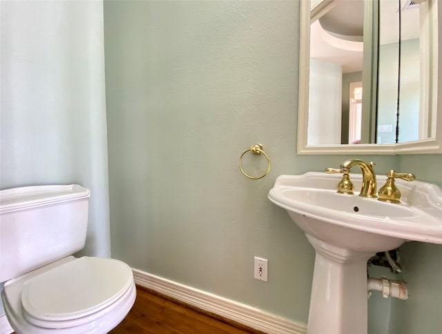 bathroom featuring wood-type flooring and toilet