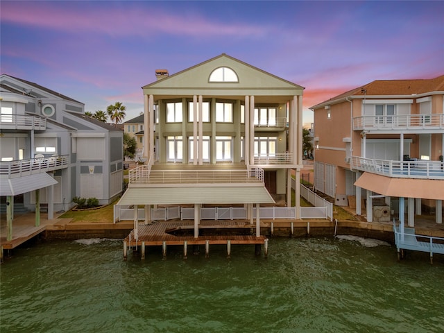 back house at dusk featuring a balcony