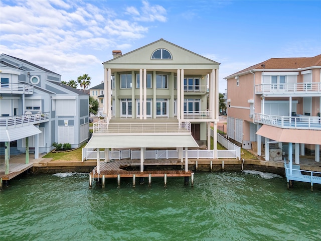 rear view of property with a balcony and a water view