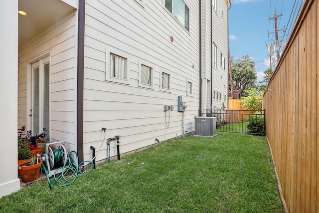 view of property exterior featuring central air condition unit and a lawn