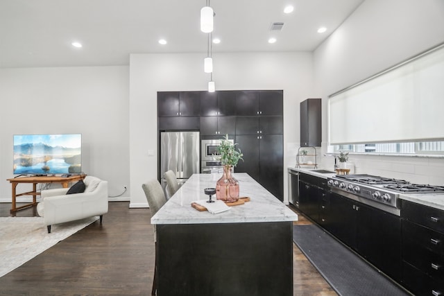 kitchen with pendant lighting, dark wood-type flooring, stainless steel appliances, and a kitchen island