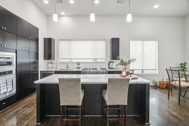 kitchen with pendant lighting, appliances with stainless steel finishes, and a center island