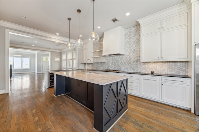 kitchen featuring tasteful backsplash, ornamental molding, dark wood-type flooring, and white cabinets