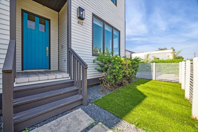 view of exterior entry with a lawn