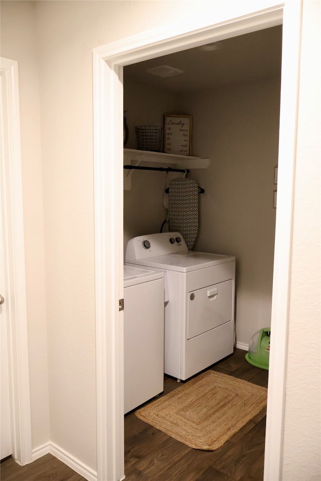 clothes washing area with dark wood-type flooring and washing machine and clothes dryer