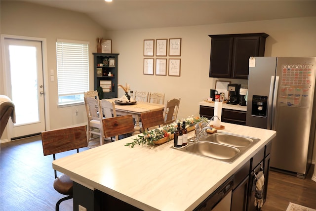 kitchen featuring a kitchen island with sink, vaulted ceiling, sink, dark hardwood / wood-style floors, and appliances with stainless steel finishes