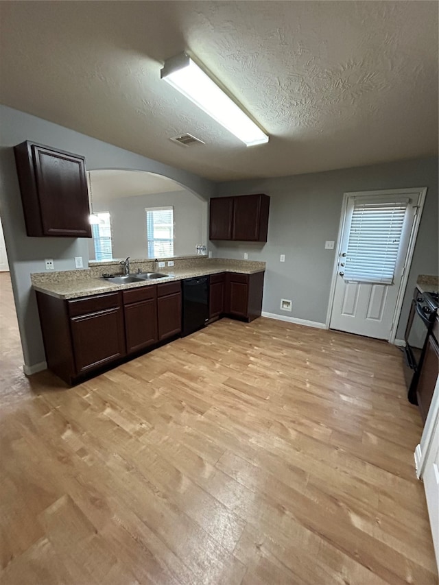 kitchen featuring light wood-type flooring, black appliances, dark brown cabinetry, and sink