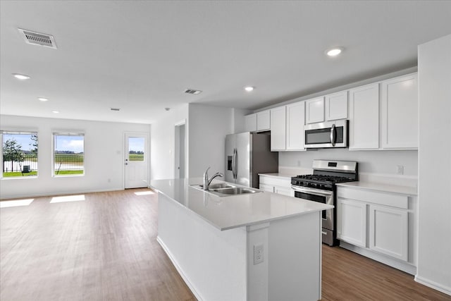 kitchen featuring a center island with sink, stainless steel appliances, sink, and white cabinetry