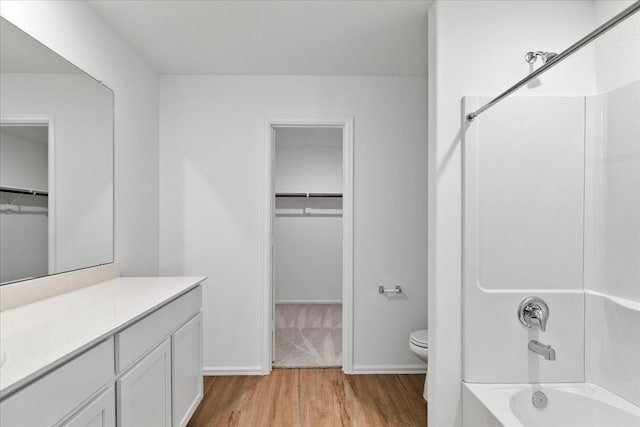 full bathroom featuring wood-type flooring, tub / shower combination, vanity, and toilet