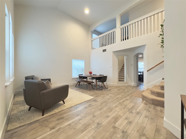 living room featuring light hardwood / wood-style flooring and high vaulted ceiling