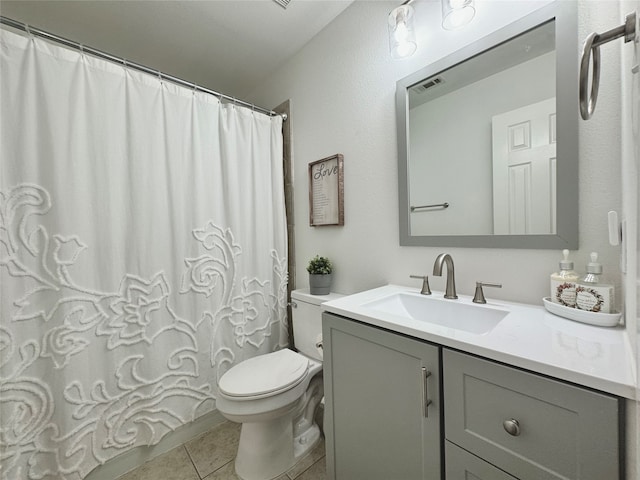 bathroom with walk in shower, vanity, tile patterned flooring, and toilet