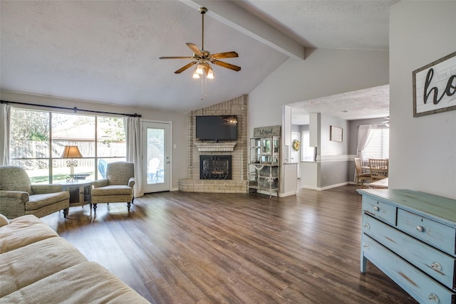 living room featuring a textured ceiling, beam ceiling, a fireplace, dark hardwood / wood-style flooring, and ceiling fan