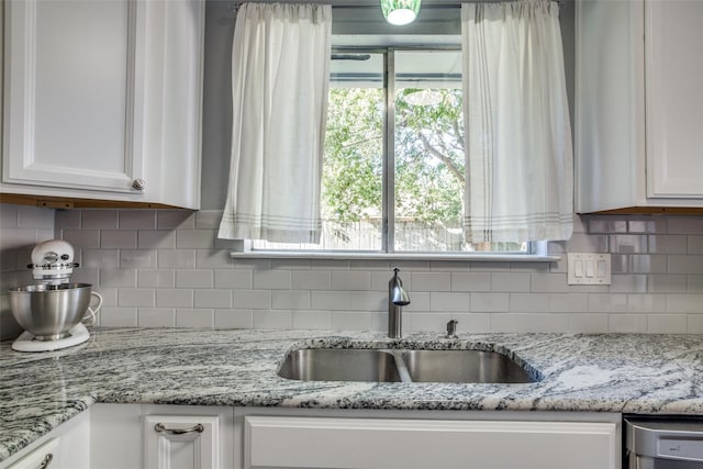 kitchen featuring decorative backsplash, sink, and white cabinets