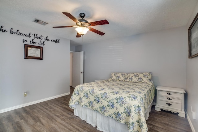 bedroom featuring a textured ceiling, dark wood-type flooring, and ceiling fan