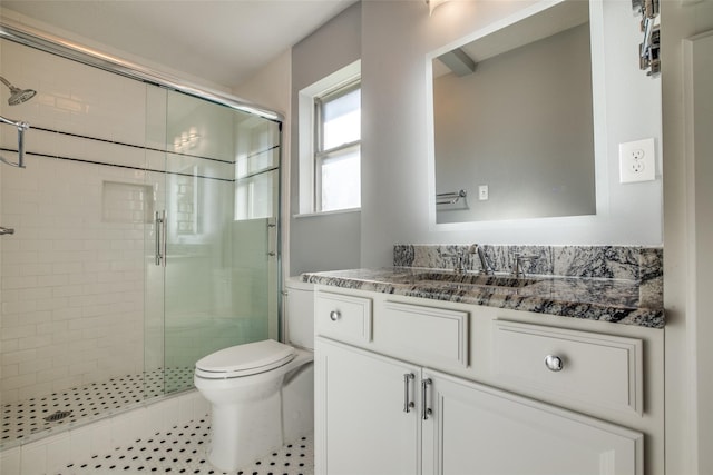 bathroom featuring tile patterned floors, a shower with shower door, vanity, and toilet