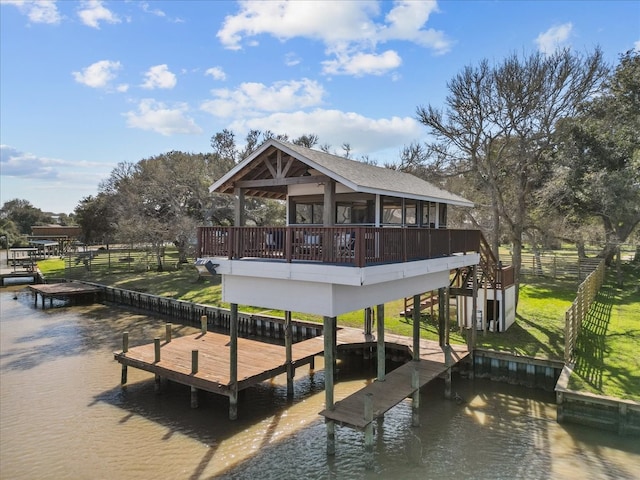 view of dock featuring a deck with water view and a yard