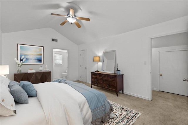 carpeted bedroom featuring visible vents, baseboards, ensuite bathroom, ceiling fan, and vaulted ceiling