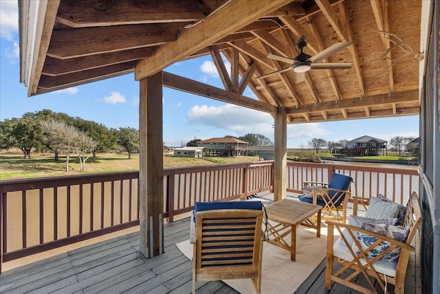 wooden deck with a water view, ceiling fan, a residential view, and a gazebo
