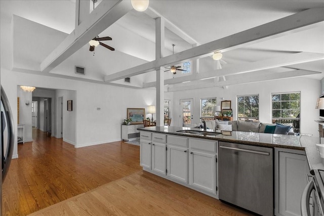 kitchen featuring stainless steel dishwasher, a ceiling fan, visible vents, open floor plan, and a sink