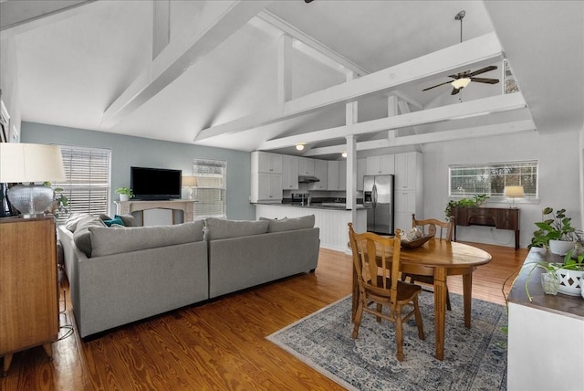 dining area with beamed ceiling, a ceiling fan, high vaulted ceiling, and wood finished floors