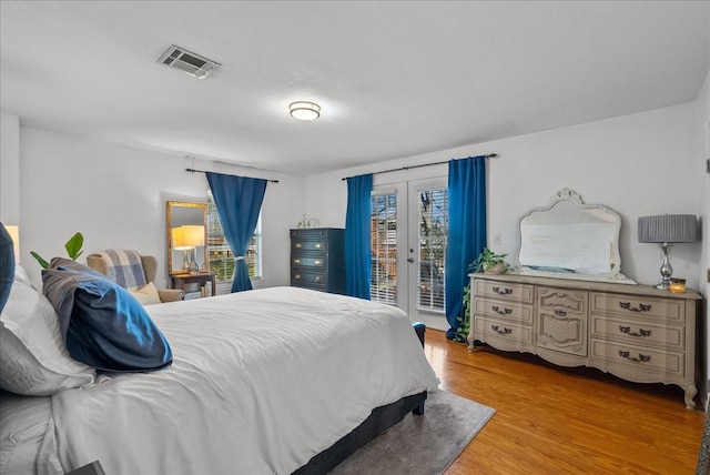 bedroom featuring visible vents, access to exterior, french doors, and light wood-style flooring
