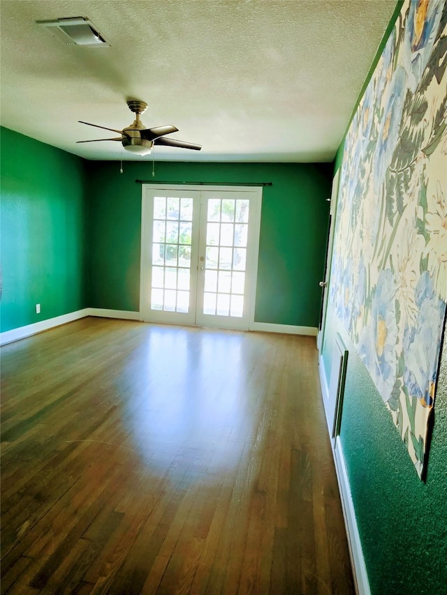 spare room with ceiling fan, dark hardwood / wood-style floors, a textured ceiling, and french doors