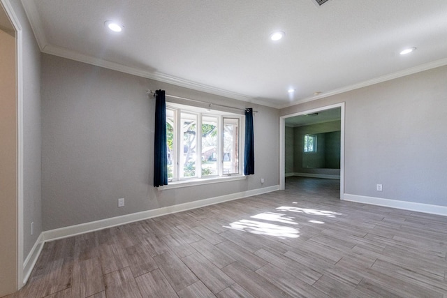 spare room with light wood-type flooring, baseboards, crown molding, and recessed lighting