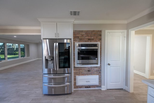 kitchen with visible vents, baseboards, white cabinetry, ornamental molding, and appliances with stainless steel finishes