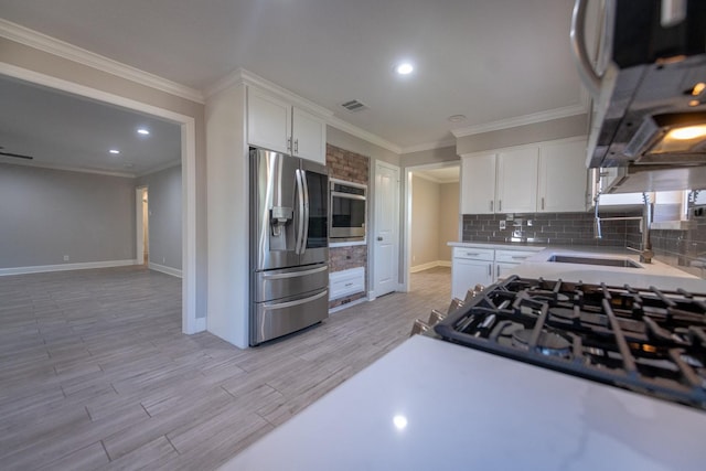 kitchen with appliances with stainless steel finishes, backsplash, visible vents, and white cabinets