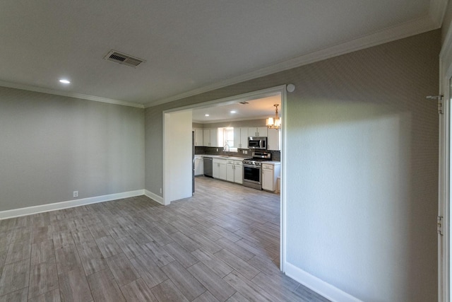 kitchen featuring stainless steel appliances, visible vents, light wood-style flooring, white cabinets, and baseboards